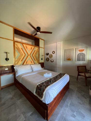 um quarto com uma cama grande e uma ventoinha de tecto em Chief Mau Moalboal Cebu em Moalboal