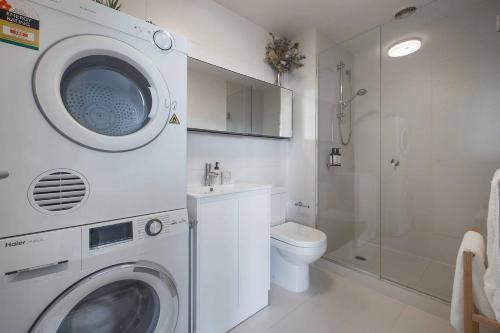a bathroom with a washing machine and a toilet at Eden of Abbotsford - A Serene Escape off Johnston St in Melbourne