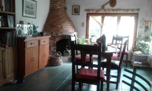 sala de estar con chimenea de ladrillo, mesa y sillas en Habitacion privada Stella Maris en Río Ceballos