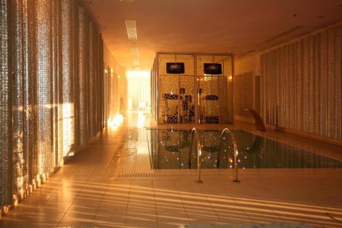 a room with a swimming pool in a building at Salvator Villas & Spa Hotel in Parga
