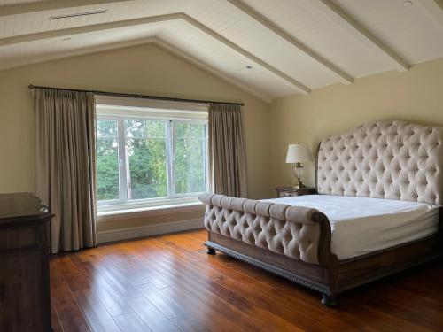 a large bedroom with a large bed and a window at Spacious Cozy House in Vancouver West in Vancouver