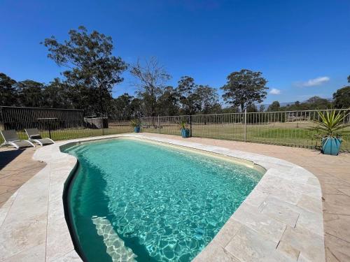 a swimming pool with blue water in a yard at Amani in Pokolbin