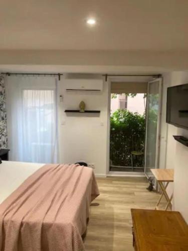 um quarto com uma cama e uma porta de vidro deslizante em Haven of peace near the historic center em Perpignan