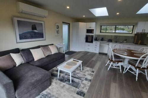 uma sala de estar com um sofá e uma mesa em Private Getaway Close to Clifton Beach em Hobart