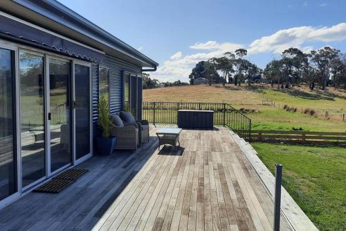 eine Terrasse mit einem Sofa und einem Stuhl auf einem Haus in der Unterkunft Private Getaway Close to Clifton Beach in Hobart