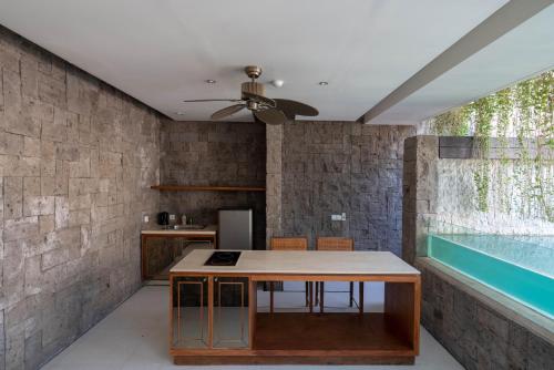 a kitchen with a table and a ceiling fan at Berry Amour Romantic Villas in Seminyak