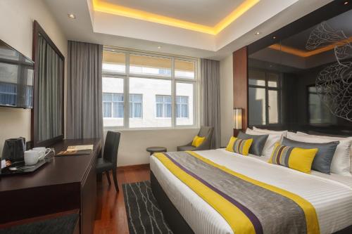 Habitación de hotel con cama grande y escritorio. en Renuka City Hotel, en Colombo