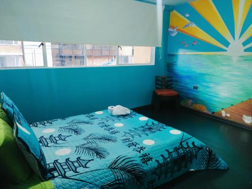 Schlafzimmer mit einem Bett mit blauer Wand in der Unterkunft 82Hostel in Bogotá