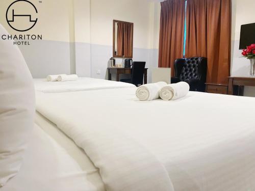 ジョホールバルにあるChariton Hotel Skudai Kiriのホテルルーム内のベッド2台(タオル付)