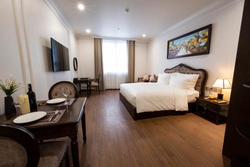 Habitación grande con cama y mesa en MADELISE HOTEL&APARTMENT, en Hai Phong
