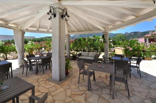 a patio with tables and chairs under a pavilion at B&B I Graniti Sardi in Villasimius