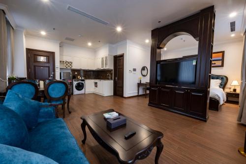 a living room with a blue couch and a tv at MADELISE HOTEL&APARTMENT in Hai Phong