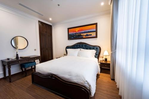 a bedroom with a bed and a table and a mirror at MADELISE HOTEL&APARTMENT in Hai Phong