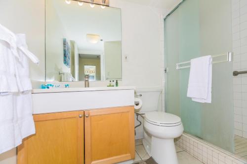 a bathroom with a toilet and a sink and a mirror at Ilikai Tower 618 Lagoon View 1BR in Honolulu
