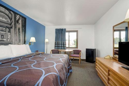 Habitación de hotel con cama y TV de pantalla plana. en Budget Host Inn, en Buffalo