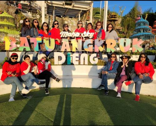 a group of women posing for a picture in front of a sign at Homestay Ngaso Dalem in Wonosobo