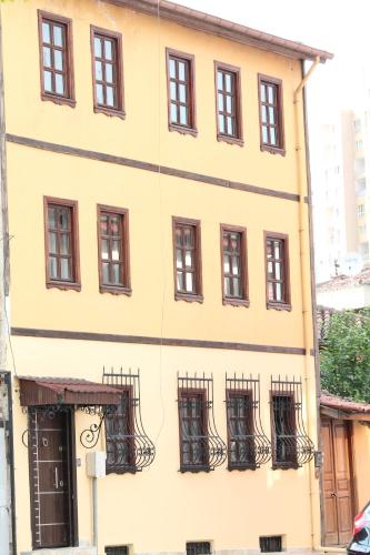 a yellow building with black balconies on it at Lena Central Flats in Bursa
