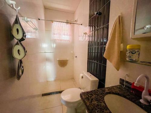 La salle de bains est pourvue de toilettes, d'une douche et d'un lavabo. dans l'établissement Casa na Praia de Guaratiba - Maricá, à Maricá