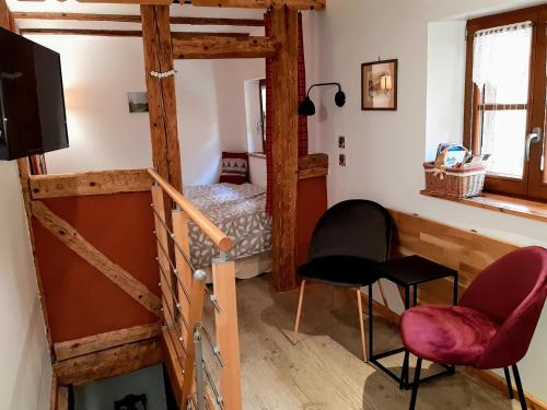 ein Zimmer mit einer Treppe und ein Schlafzimmer mit einem Bett in der Unterkunft Gîte Pfaffenheim, 2 pièces, 2 personnes - FR-1-744-8 in Pfaffenheim