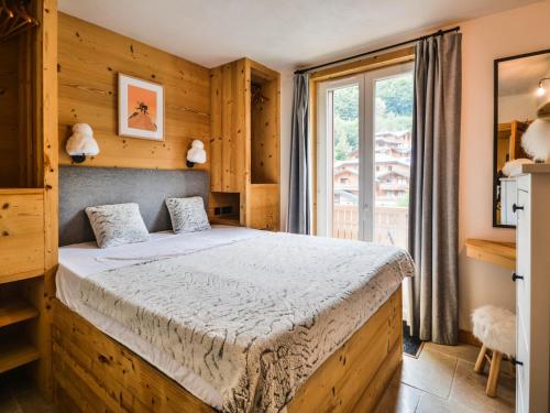 une chambre avec un lit et une grande fenêtre dans l'établissement Appartement 6 pers. avec WiFi, proche pistes et centre – Morzine - FR-1-684-65, à Morzine