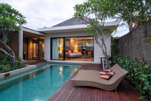 a villa with a swimming pool and a house at Berry Amour Romantic Villas in Seminyak