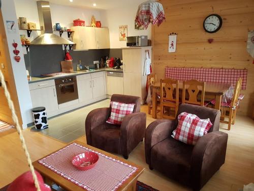 Il comprend une cuisine et un salon avec des chaises et une table. dans l'établissement Appartement 2 pièces, 5 pers, au centre de Châtel avec balcon, parking et connexion WiFi - FR-1-676-13, à Châtel