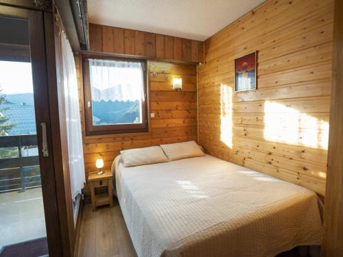 une chambre avec un lit dans une cabane en bois dans l'établissement Studio pour 4 pers avec balcon exposé sud, parking couvert, WIFI, proche télésiège et navettes - FR-1-676-16, à Châtel