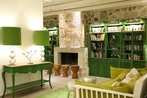a living room with a green couch and a fireplace at Salvator Villas & Spa Hotel in Parga