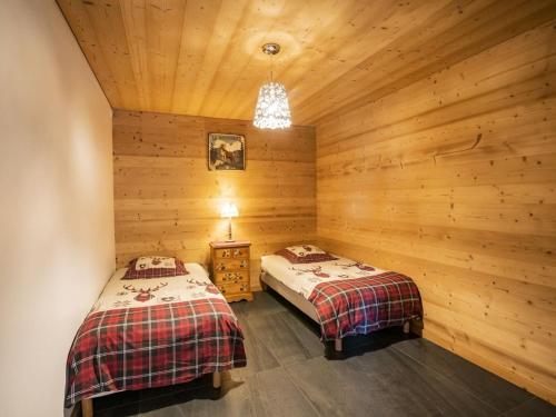 two beds in a room with wooden walls at Charmant chalet 3 pièces pour 6 pers avec terrasse à Châtel, proche centre et télécabine. - FR-1-676-14 in Châtel