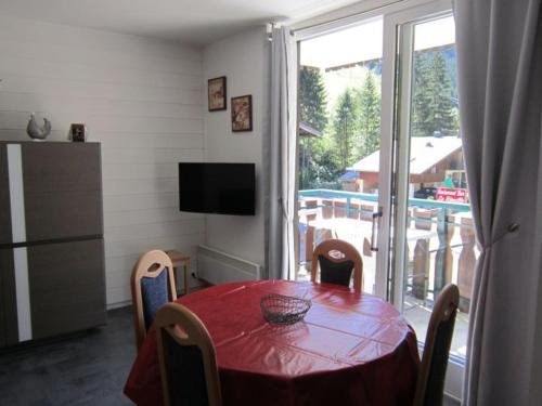 une salle à manger avec une table et une grande fenêtre dans l'établissement Studio cosy pour 4 pers. avec balcon, à 100m des remontées mécaniques du Linga, offre WiFi et TV - FR-1-676-15, à Châtel
