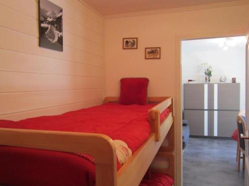 - une chambre avec un lit rouge et un réfrigérateur dans l'établissement Studio cosy pour 4 pers. avec balcon, à 100m des remontées mécaniques du Linga, offre WiFi et TV - FR-1-676-15, à Châtel
