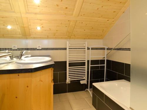 une salle de bain avec un lavabo et une baignoire dans l'établissement Spacieux 4 pièces avec mezzanine, balcon et parking, à 2 pas de Super-Châtel - 7 pers. - FR-1-676-25, à Châtel