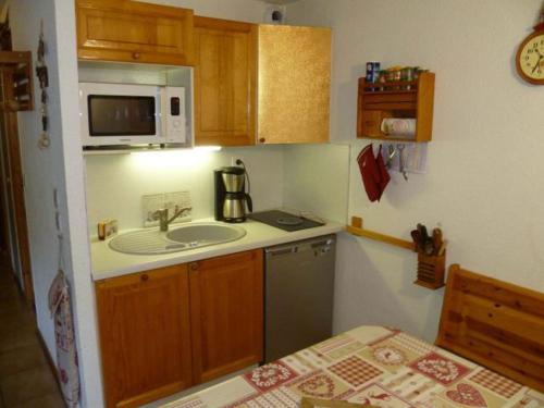 une petite cuisine avec un évier et un micro-ondes dans l'établissement Appartement 2 pièces cosy, 5 pers, terrasse sud, proche des remontées, parking inclus, WiFi en option - FR-1-676-51, à Châtel