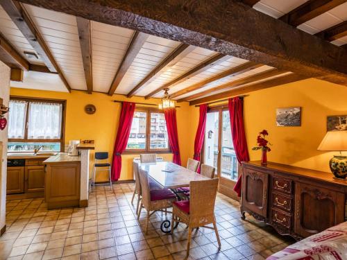 - une cuisine et une salle à manger avec une table et des rideaux rouges dans l'établissement Appartement spacieux 3 pièces, balcon exposé sud, proximité centre et remontées mécaniques, 6 pers. - FR-1-676-20, à Châtel