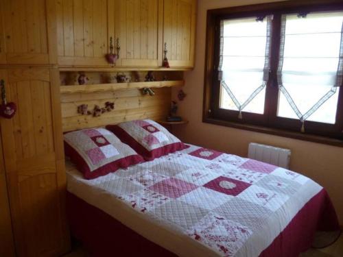 une chambre avec un lit avec une couette dessus dans l'établissement Appartement 2 pièces cosy, 5 pers, terrasse sud, proche des remontées, parking inclus, WiFi en option - FR-1-676-51, à Châtel