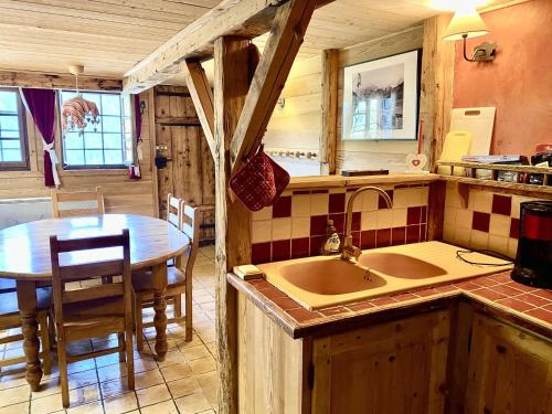 - une cuisine avec un évier et une table dans une chambre dans l'établissement Chalet 4 pièces, 3 chambres, 8 pers., proche télécabine, balcon, jardin privatif, parking, Wifi - FR-1-676-40, à Châtel