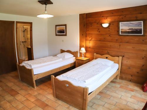 two beds in a room with wooden walls at Chalet Châtel, 4 pièces, 9 personnes - FR-1-676-44 in Châtel