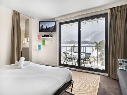a hotel room with a bed and a large window at Celesia 2 in Thredbo