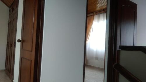 una puerta que conduce a una habitación con ventana en Cómoda, amoblada y cálida habitación cerca al portal 80, en Bogotá