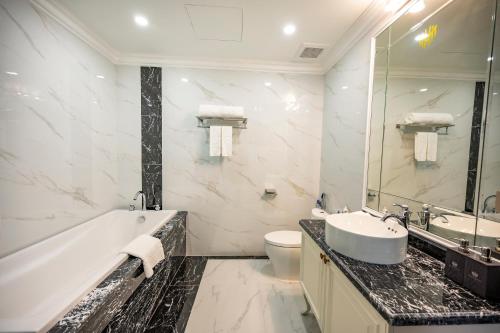 y baño con bañera, lavabo y aseo. en MADELISE HOTEL&APARTMENT, en Hai Phong