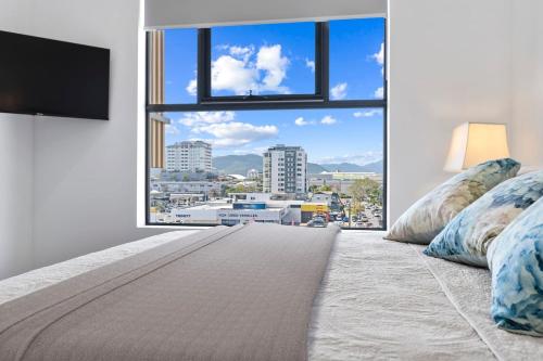 um quarto com uma grande janela com vista para a cidade em Mountain Air and Modern Flair 'Your Cairns Getaway' em Cairns