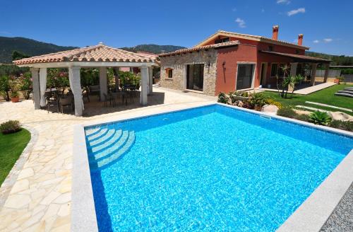 a swimming pool in front of a house at B&B I Graniti Sardi in Villasimius