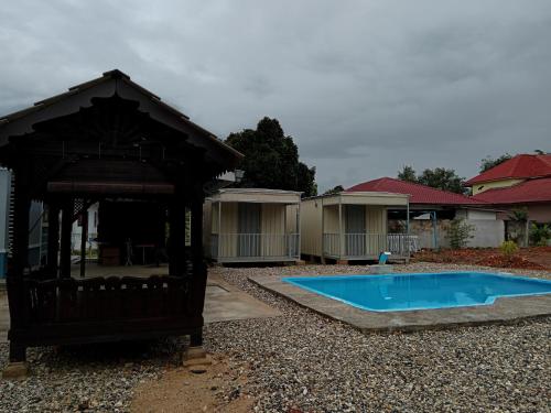 a small pool in a yard with a gazebo at Homestay Pinang Tunggal Cabin in Sungai Petani