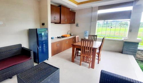 a kitchen with a table and chairs and a refrigerator at Rama Bharata Villa in Ubud