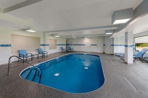a large pool in a room with chairs and tables at Comfort Inn & Suites Tipp City Dayton North I-75 in Tipp City