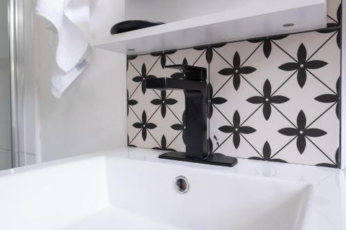 a bathroom sink with a black faucet on a wall at Jamaica Time Driftwood at Sea Palms 3BR 3BA Condo in Ocho Rios with Pool and Beach Front with Views ONLY 10 Mins from Ochi Intl Airport Direct flight from Miami in St Mary