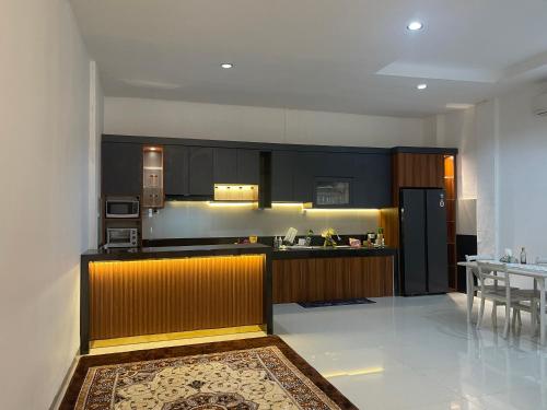 a kitchen with black cabinets and a counter top at Bagus house in Pekanbaru