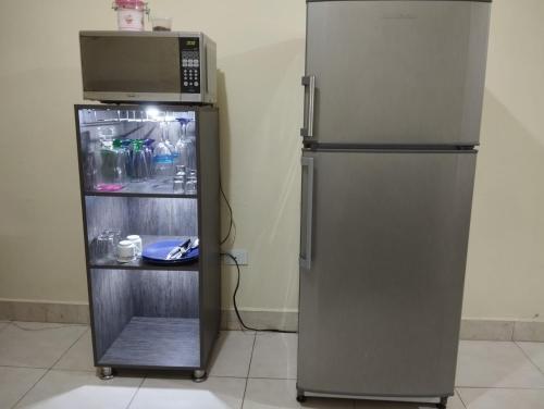 a refrigerator with a microwave on top of it at LUKAAM in Medellín