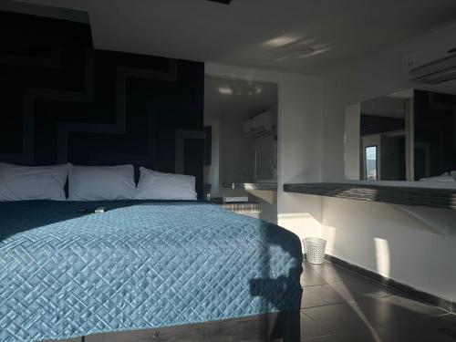 a bedroom with a bed with a blue comforter at Ya no tenemos servicio in Mexico City