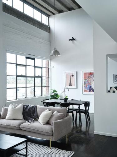 a living room with a couch and a table at Chic Urban Loft in Prime Location in Melbourne